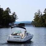 Stewart Woodworth at the helm of his boat as he looked for uncharted rocks on Winnipesaukee.