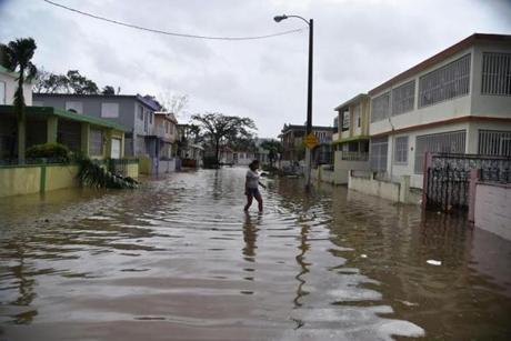 A resident of the Puerto Nuevo neighborhood walks through flood water during the passage of Hurricane Maria.
