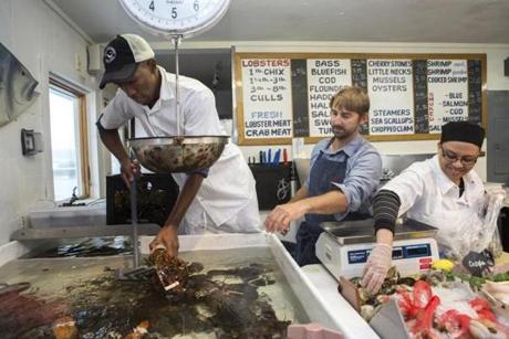 Mac Hay (center), owner of Mac?s Seafood on Cape Cod, worked with two of his many H-2B visa employees, Robert Camblell (left), and Marlene Betty, both of Jamaica.  
