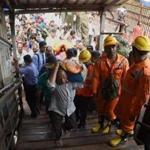 Indian rescue personnel walk through the scene of a stampede on a railway bridge in Mumbai.