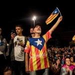 BARCELONA, SPAIN - OCTOBER 01: People hold Catalan flags as they listen to Catalan President Carles Puigdemont speak via a televised press conference as they await the result of the Indepenence Referendum at the Placa de Catalunya on October 1, 2017 in Barcelona, Spain. More than five million eligible Catalan voters are estimated to visit 2,315 polling stations today for Catalonia's referendum on independence from Spain. The Spanish government in Madrid has declared the vote illegal and undemocratic. (Photo by Chris McGrath/Getty Images)