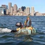 After taking off from Jeffries Yacht Club in East Boston, Christian Ilsley piloted his pumpkin boat across Boston Harbor on Sunday.