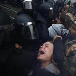 A young woman grimaced as Spanish police pushed away referendum supporters outside a polling station in Barcelona.
