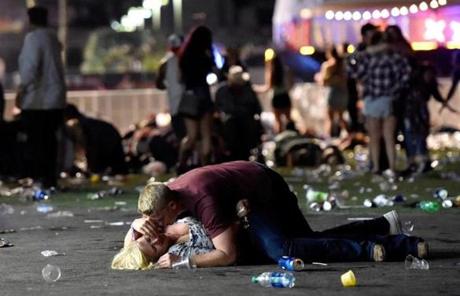 LAS VEGAS, NV - OCTOBER 01: A man lays on top of a woman as others flee the Route 91 Harvest country music festival grounds after a active shooter was reported on October 1, 2017 in Las Vegas, Nevada. A gunman has opened fire on a music festival in Las Vegas, leaving at least 2 people dead. Police have confirmed that one suspect has been shot. The investigation is ongoing. (Photo by David Becker/Getty Images)
