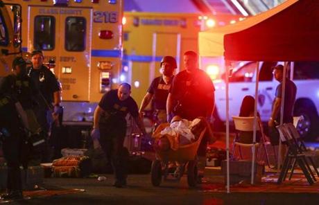LAS VEGAS SLIDER2 A wounded person is walked in on a wheelbarrow as Las Vegas police respond during an active shooter situation on the Las Vegas Stirp in Las Vegas Sunday, Oct. 1, 2017. Multiple victims were being transported to hospitals after a shooting late Sunday at a music festival on the Las Vegas Strip. (Chase Stevens/Las Vegas Review-Journal via AP)
