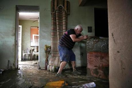 Toa Baja, Puerto Rico -- 9/30/2017 - Geraldo Rivera, 51, helps his neighbor move a dresser ruined in the flood waters inside the home on Avenida Calle Palma Villa Calma after Hurricane Maria. (Jessica Rinaldi/Globe Staff) Topic: Reporter: 
