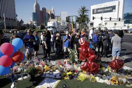 People pause at a memorial for the victims of a mass shooting in Las Vegas, Wednesday, Oct. 4, 2017, in Las Vegas. A gunman opened fire on an outdoor music concert on Sunday killing dozens and injuring hundreds. (AP Photo/John Locher)
