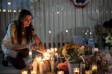 Las Vegas resident Dashenka Giraldo lights candles at a makeshift memorial at the northern end of the Last Vegas Strip.
