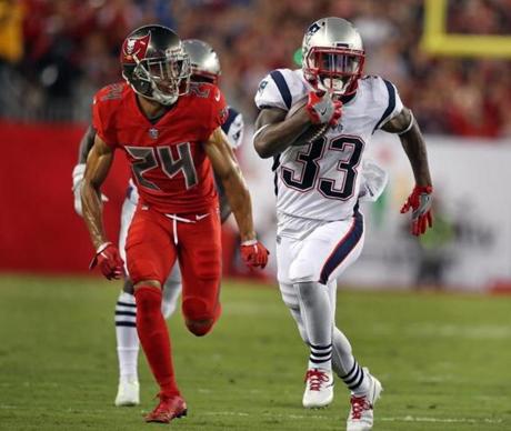Tampa, FL: October 3, 2017: Patriots running back Dion Lewis (33) breaks away from Tampa Bay CB Brent Grimes (24) for a first quarter ong gain that gave the Patriots a first and 10 at the Tampa Bay 14 yard line and set up the first New England field goal of the game. The New England Patriots visited the Tampa Bay Buccaneers in a regular season Thursday Night NFL football game at Raymond James Stadium. (Jim Davis/Globe Staff). 
