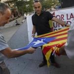Demonstrators cut the star from a Catalan pro-independence flag during a protest against the independence of Catalonia in Madrid on Saturday. 