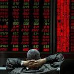 An investor looked at stock market prices on a display at a brokerage in Beijing on Monday.