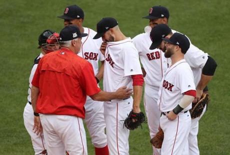 BOSTON, MA 10/09/2017 Red Sox pitching coach Carl Willis (left) spoke to pitcher Rick Porcello after he hit Astros Marwin Gonzalez on the elbow in the first inning. The Boston Red Sox host the Houston Astros in Game Four of the ALDS at Fenway Park in Boston on Oct. 9, 2017. (Stan Grossfeld/Globe Staff) 
