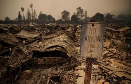 WILDFIRES SLIDER SANTA ROSA, CA - OCTOBER 09: A sign stands next to fire damaged mobile homes at the Journey's End Mobile Home Park on October 9, 2017 in Santa Rosa, California. Ten people have died in wildfires that have burned tens of thousands of acres and destroyed over 1,500 homes and businesses in several Northen California counties. (Photo by Justin Sullivan/Getty Images)
