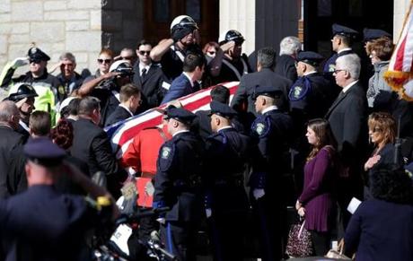 Pallbearers carried the American flag-draped coffin of Somerville Officer Louis M. Remigio at St. Clement Church in Medford.
