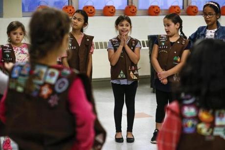 Eight-year-old Rebekah Foote (center) and others gathered for a Girl Scout troop meeting at Daley Middle School in Lowell.
