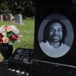 FILE - In this July 6, 2017, file photo, a bouquet of flowers adorns the grave of Philando Castile on the one year anniversary of his death at Calvary Cemetery in St. Louis. Phelix Frazier Sr., the father of Philando Castile, a motorist fatally shot by a suburban Minneapolis police officer last summer, wants a portion of the $3 million settlement reached in his son's death. Frazier is serving a life term in federal prison on drug trafficking charges. (David Carson/St. Louis Post-Dispatch via AP, File)