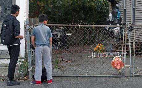Lowell, MA: 10-23-17: Two neighborhood children pause and check out the memorial at the scene where a 7 year old boy was mauled to death by two pit bull dogs on Saturday on Clare Street. (Jim Davis/Globe Staff)
