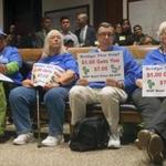 Massachusetts Senior Action Council members held signs Monday at a State House health care hearing.