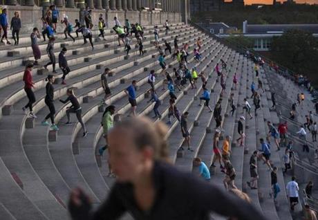 A stair climber at Harvard Stadium uses a cellphone to light the way. 
