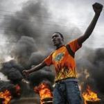 A backer of opposition presidential candidate Raila Odinga stood by a burning barricade in Nairobi on Wednesday.