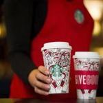 This Monday, Oct. 23, 2017, photo provided by Starbucks shows the company's 2017 holiday cup on display in Seattle. This latest holiday cup is mostly white, for customers to color in themselves. (Joshua Trujillo/Starbucks via AP)