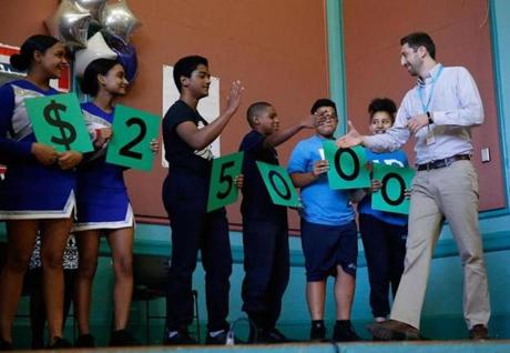 Daniel Adler, a sixth grade Science teacher at Up Academy Leonard, in Lawrence shook hands with students as he took the stage after being named the recipient of the $25,000 Milken Award.
