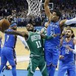 Celtics guard Kyrie Irving (11) goes to some length to shoot over Thunder guard Andre Roberson (21) in the second quarter.