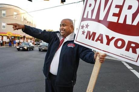 Lawrence Mayor Dan Rivera holding a sign waves at motorists at the corner of Park and Lawrence Streets in Lawrence, MA. Friday, Oct. 13, 2017. Lawrence Mayor Dan Rivera, who has been trying to steer this city's ship straight, faces a fierce challenge in November from William Lantigua, the notorious mayor he ousted four years ago with promises to clean up the city. CREDIT: Cheryl Senter for The Boston Globe
