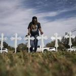 Sheree Rumph prayed over crosses that were put up outside a gas station in Sutherland Springs, Tex., on Monday.