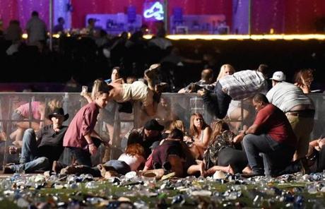 LAS VEGAS, NV - OCTOBER 01: People scramble for shelter at the Route 91 Harvest country music festival after apparent gun fire was heard on October 1, 2017 in Las Vegas, Nevada. A gunman has opened fire on a music festival in Las Vegas, leaving at least 20 people dead and more than 100 injured. Police have confirmed that one suspect has been shot. The investigation is ongoing. (Photo by David Becker/Getty Images)
