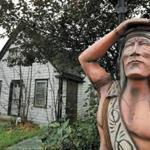 A carved wooden statue stands near a property in Sea Captains Row on Pleasant Street. A developer has proposed to tear down several 200-year-old neglected buildings for nine multifamily structures, pitting preservationists against some residents and business leaders.