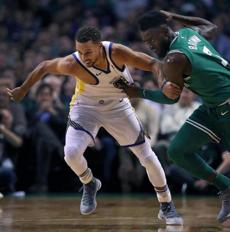 Boston, MA: 11-16-17: The Celtics Jaylen Brown (right) has a hold of the jersey of Stephen Curry, (left) and he beat him to the ball after a first quarter steal, and went coast to coast for a slam dunk. The Boston Celtics hosted the Golden State Warriors in a regular season NBA basketball game at the TD Garden. (Jim Davis/Globe Staff)
