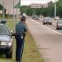 A state trooper used a radar gun to monitor vehicle speeds on Route 128 this summer.