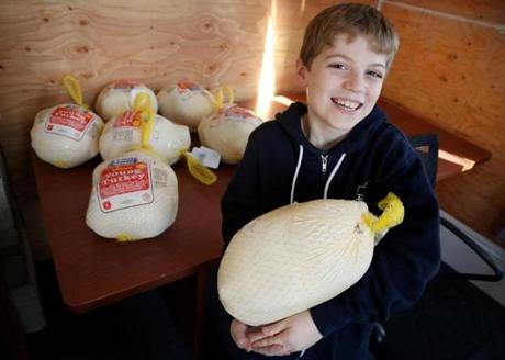 Liam Hannon, 10, with the turkeys he delivered to a Hildebrand Family Self-Help Center congregate family shelter in Cambridge on Tuesday.
