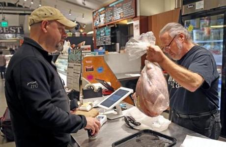 Mark Jaquith of Stillman Quality Meats handed over a turkey to Bill Koss of Newton on Wednesday.
