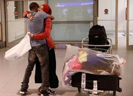 Hassan Abdullahi of Springfield (left) embraced his wife, Barlin Yarow, as she arrived from Kenya at Logan Airport. 
