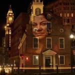 A image from the ?Boston #StandsWithImmigrants? art project, which features portraits that have been projected around the city.