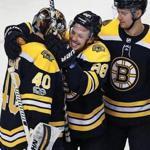Boston, MA: 11-29-17: Bruins goalie Tuukka Rask (left) gets a big hug and a smile from teammate David Pastrnak following Boston's 3-2 victory. Sean Kuraly waits for his turn at right. The Boston Bruins hosted the Tampa Bay Lightning in a regular season NHL hockey game at TD Garden. (Jim Davis/Globe Staff)