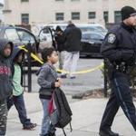 A Boston police officer escorted a group of school children past the shooting scene.
