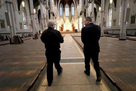 Father Kevin O'Leary (left) and John Fish of Suffolk Construction walked through the Cathedral of the Holy Cross in Boston.
