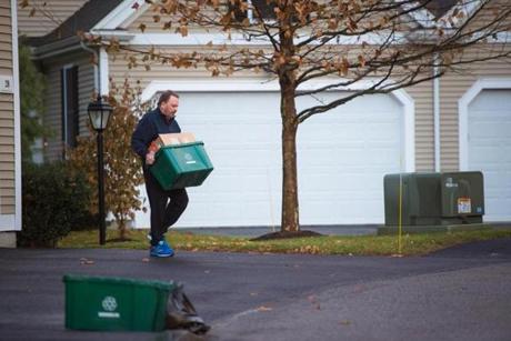 Len Zavalick took his neighbor's recycling and garbage to the curb for pick-up in Holliston.
