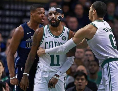 Boston, MA: 12-06-17: The Mavericks Dennis Smith Jr. (left) and the Celtics Kyrie Irving (11) had an incident under the basket in the first quarter that saw both get technical fouls called on them. Boston's Jayson Tatum (0), moves in to pull Irving away. The Boston Celtics hosted the Dallas Mavericks in a regular season NBA basketball game at the TD Garden. (Jim Davis/Globe Staff)
