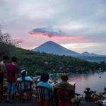 Tourists gather to watch Mount Agung at Amed beach in Karangasem on Indonesia's resort island of Bali on November 30, 2017. Thousands of foreign tourists were expected to leave Bali by plane on November 30 following a nearly three-day airport shutdown sparked by a rumbling volcano on the Indonesian holiday island. / AFP PHOTO / JUNI KRISWANTOJUNI KRISWANTO/AFP/Getty Images