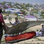 Somali men covered the body of a victim Thursday?s suicide bomb attack in Mogadishu. 