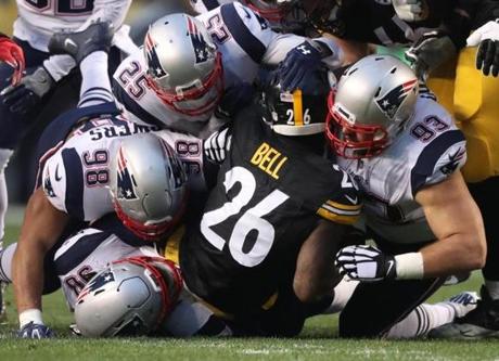 Pittsburgh, PA - 12/17/2017: Pittsburgh running back Le'Veon Bell is gang tackled by Patriots during Pittsburgh's first drive during first quarter action. The New England Patriots vs. the Pittsburgh Steelers at Heinz Field. Jim Davis / Globe staff
