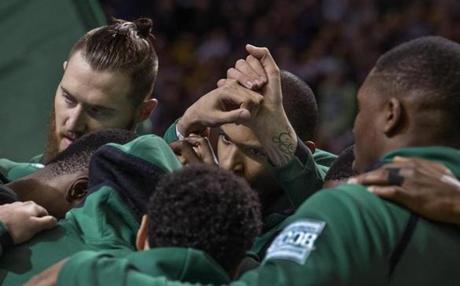 The Celtics gather around Al Horford before a game against Dallas
