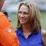 In this Saturday, July 29, 2017 photo, broadcaster Beth Mowins chats with a reporter while watching the Denver Broncos run through drills at NFL football training camp in Englewood, Colo. While Mowins is focused on football, she will become the first woman since 1987 to be the lead announcer on a nationally televised, regular season NFL game. (AP Photo/David Zalubowski)