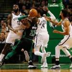 Boston, MA -- 12/31/2017 - Celtics Kyrie Irving (C) was called for an offensive foul as he drove to the basket between (l-R) Nets Quincy Acy, Rondae Hollis-Jefferson and Allen Crabbe during the first half at TD Garden. (Jessica Rinaldi/Globe Staff) Topic: Reporter: 