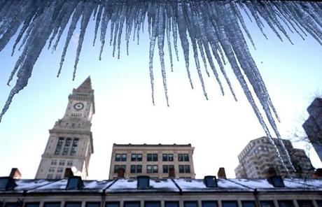 STORM SLIDER Boston, MA., 01/05/18, Icicles hang in Quincy Market with sun setting behind Custom House Tower on left. The cold continues in downtown Boston. Suzanne Kreiter/Globe staff
