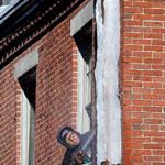 A person worked to douse hot water over ice on a Beaon Hill building.